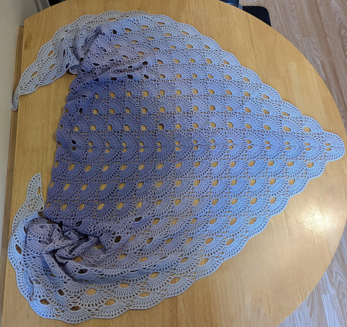 Purple crocheted shawl on a wooden table