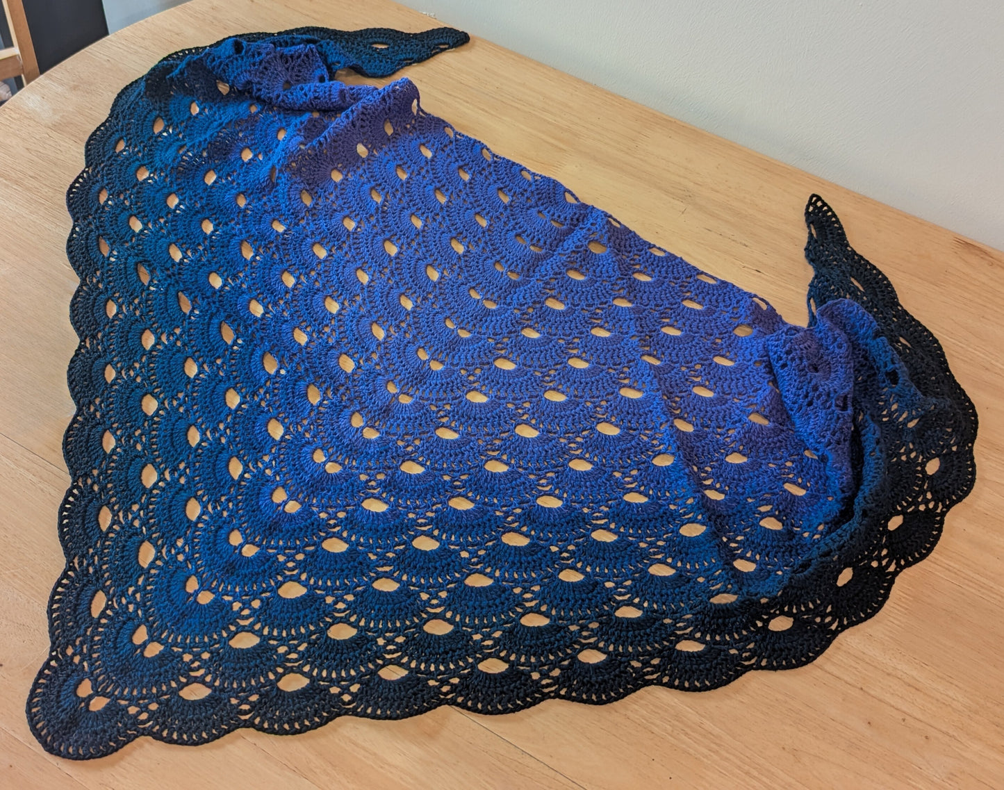 Purple crocheted shawl on a wooden table