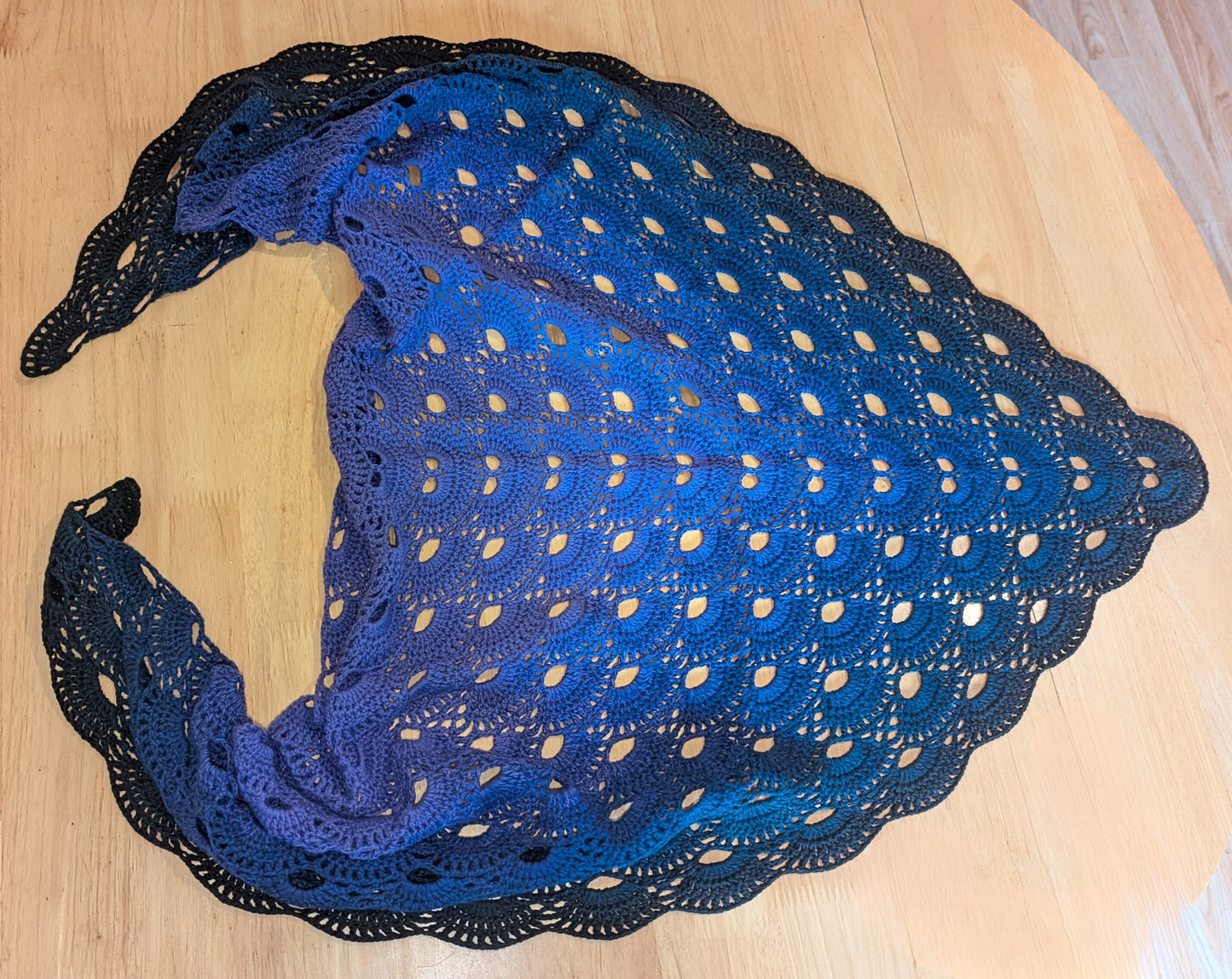 Purple lace shawl on a wooden surface