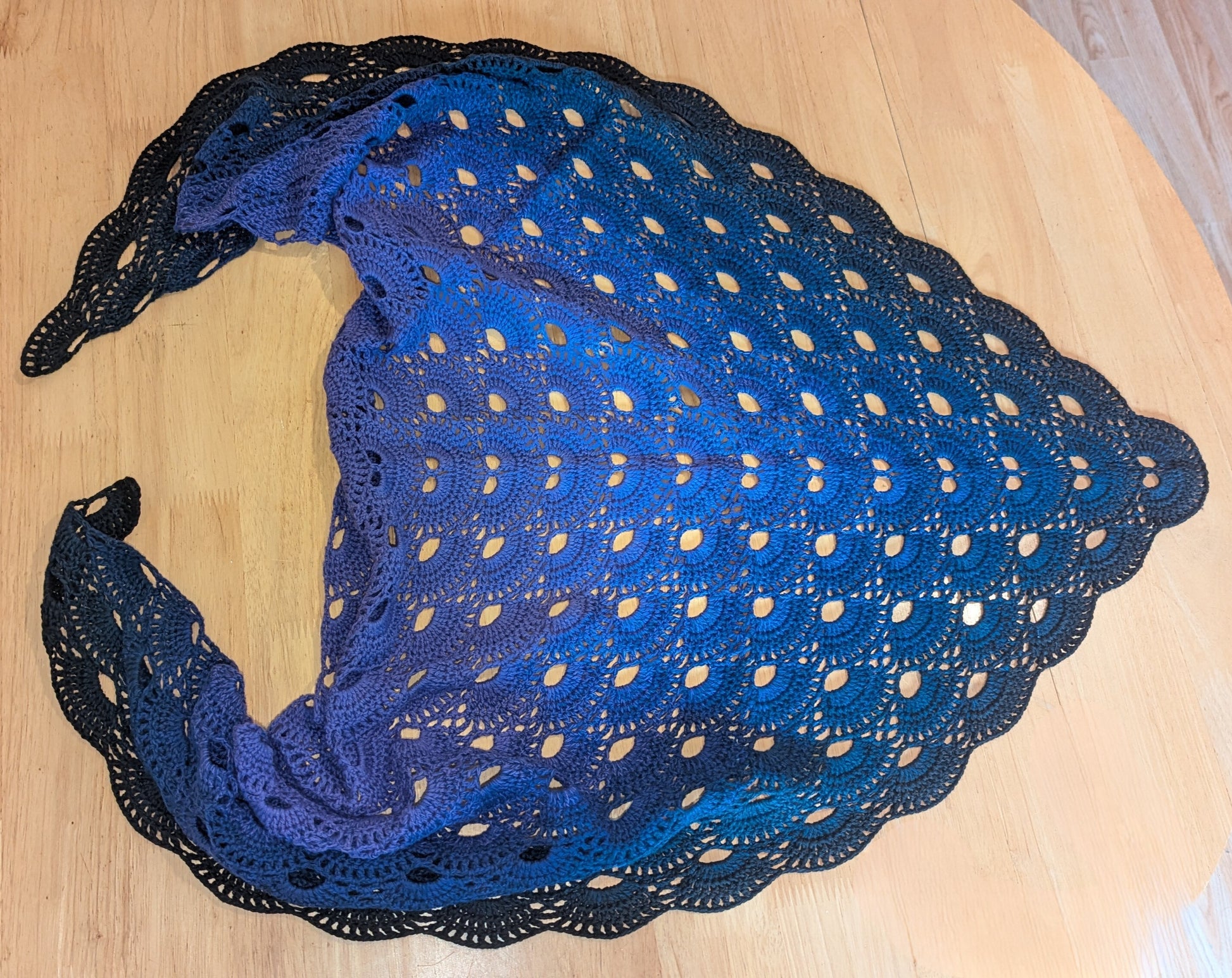 Purple lace shawl on a wooden surface