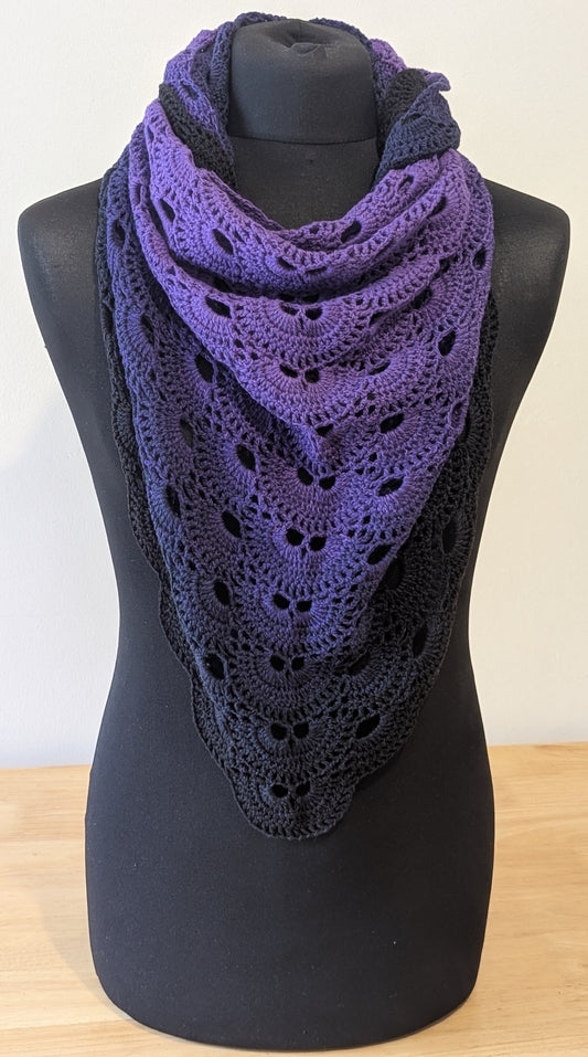 Purple lace shawl on a black mannequin against a white background