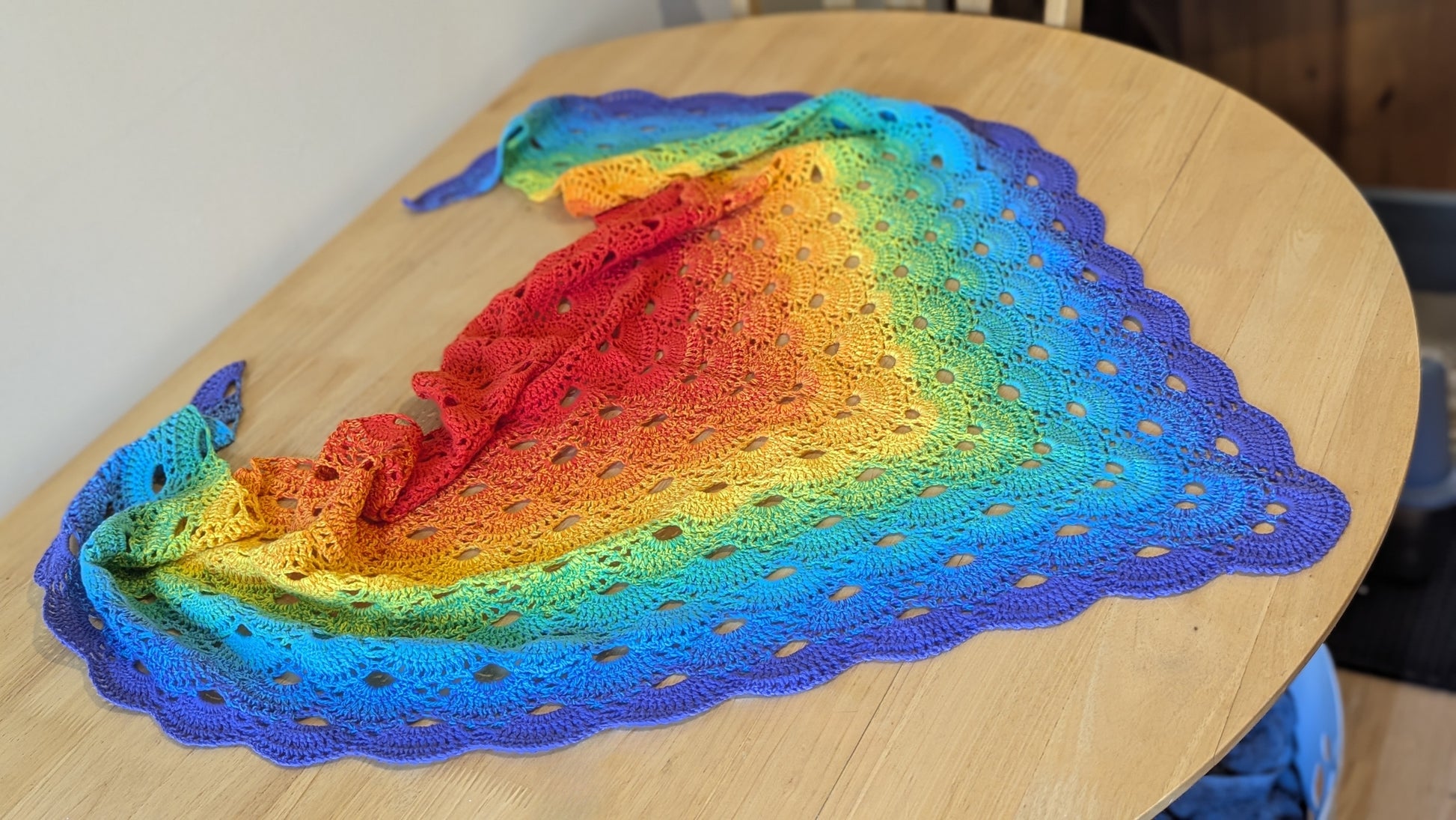 Colorful crochet scarf on a wooden table