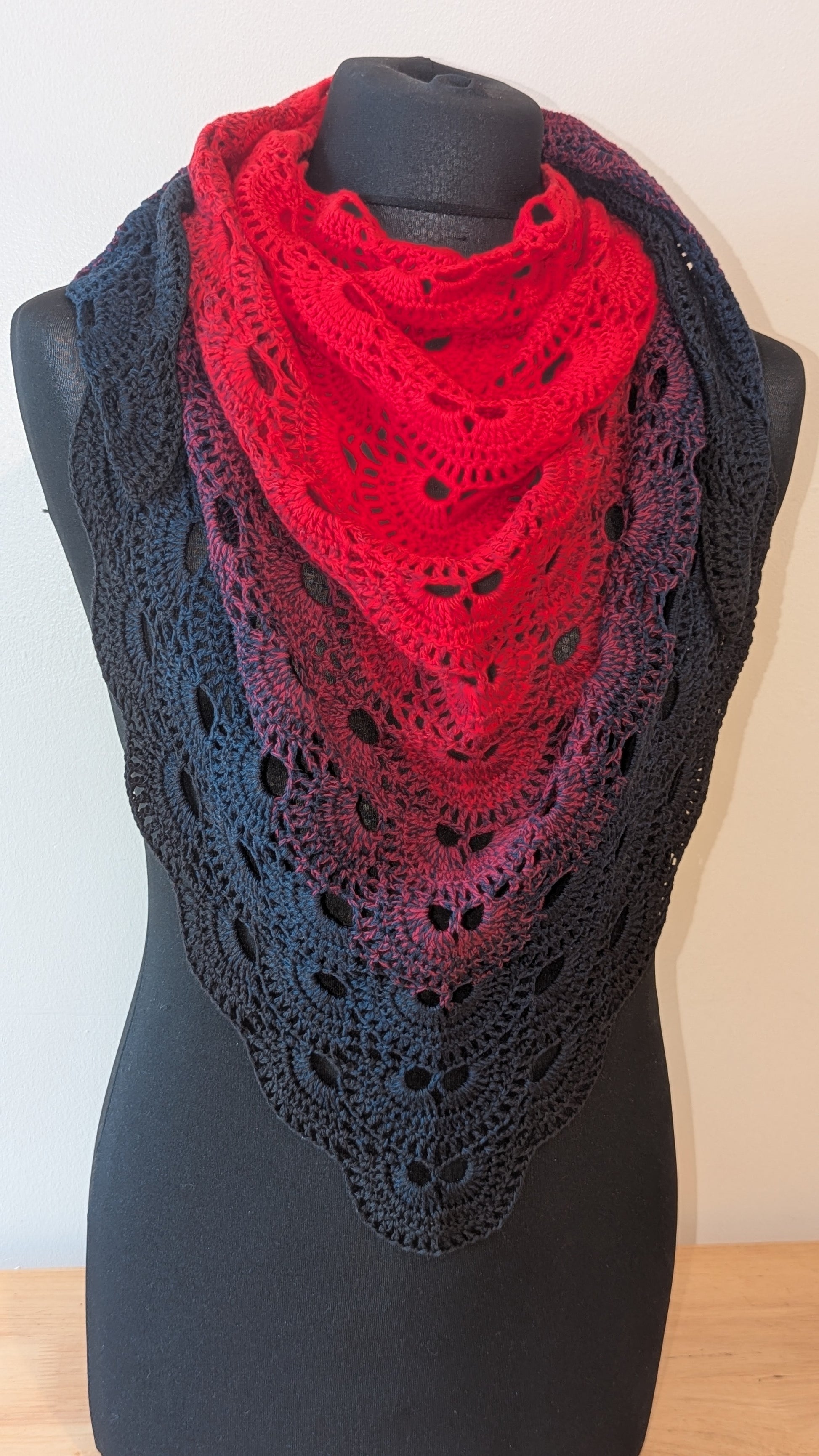 Black and red lace shawl on a mannequin against a plain background