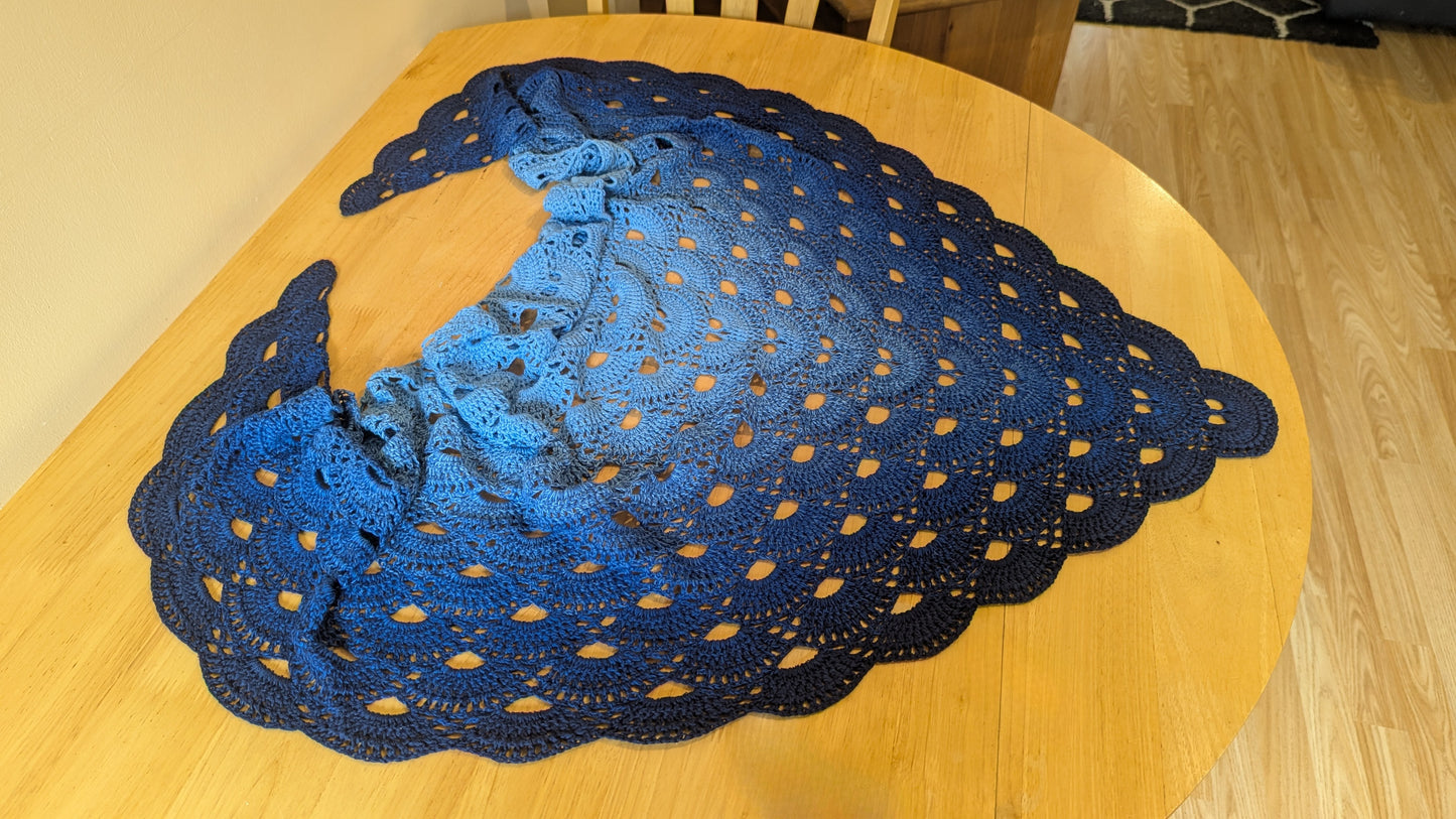 Blue gradient lacey shawl on a wooden table