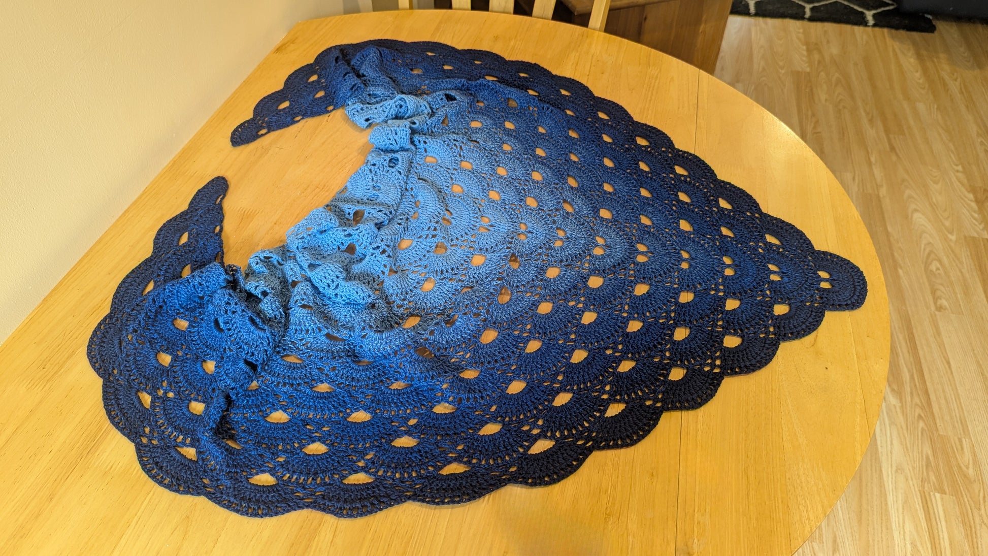 Blue gradient lacey shawl on a wooden table