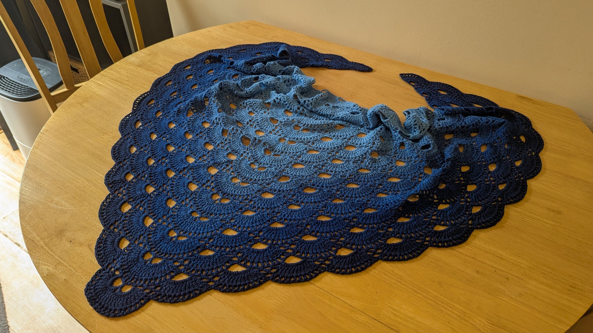 Blue crocheted shawl on a wooden table