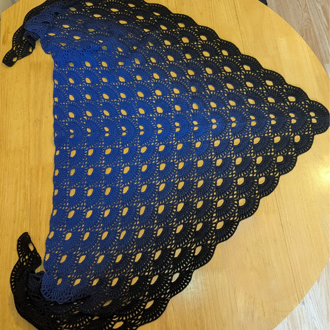 Blue and black gradient shawl on a wooden surface